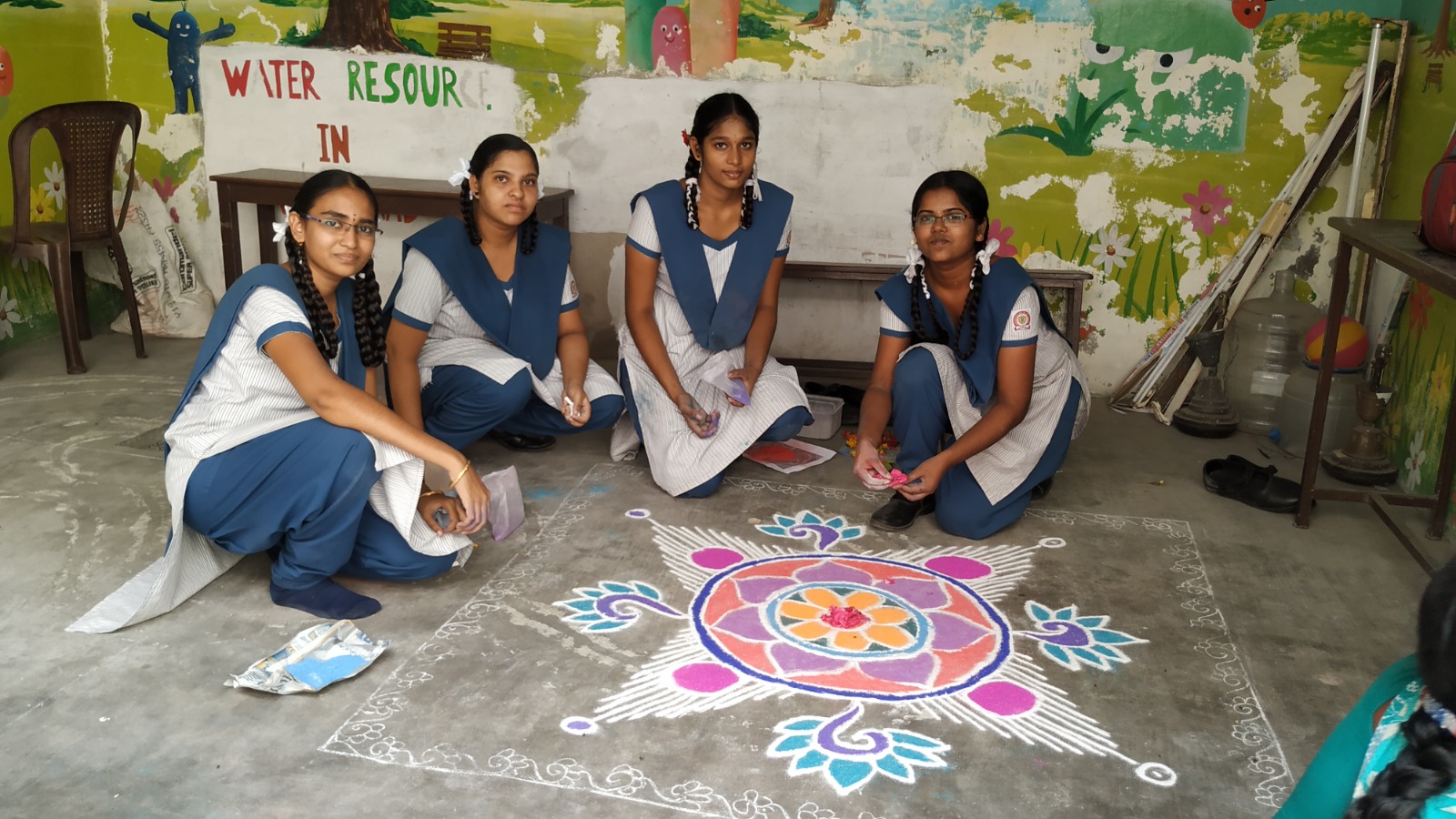 Students creating a colourful rangoli during a school competition